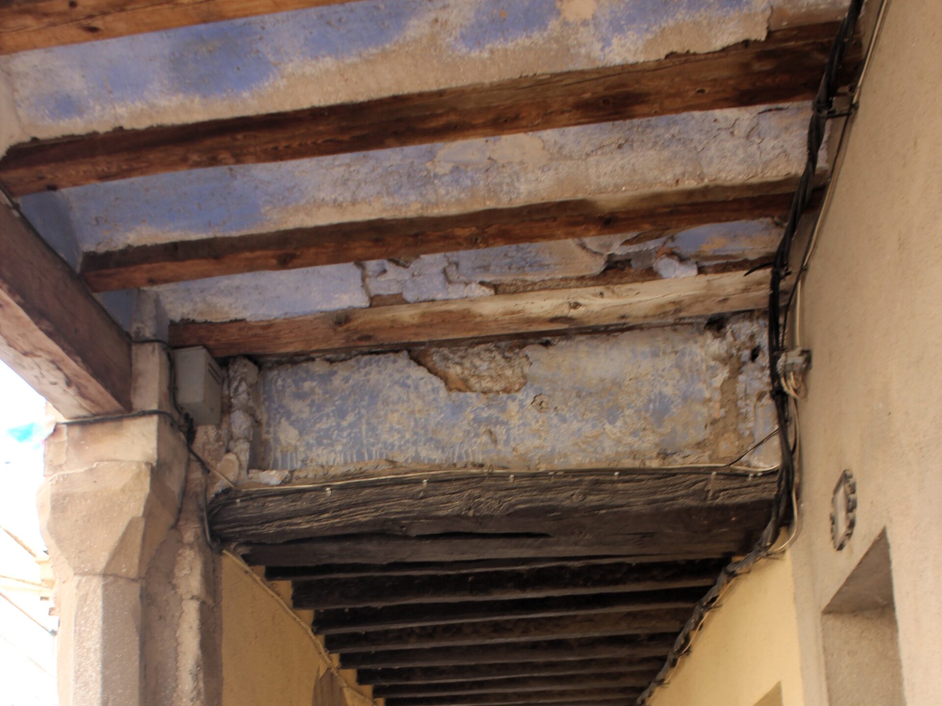Calles porticadas de vigas de madera y techo azul en el Matarraña. Teruel