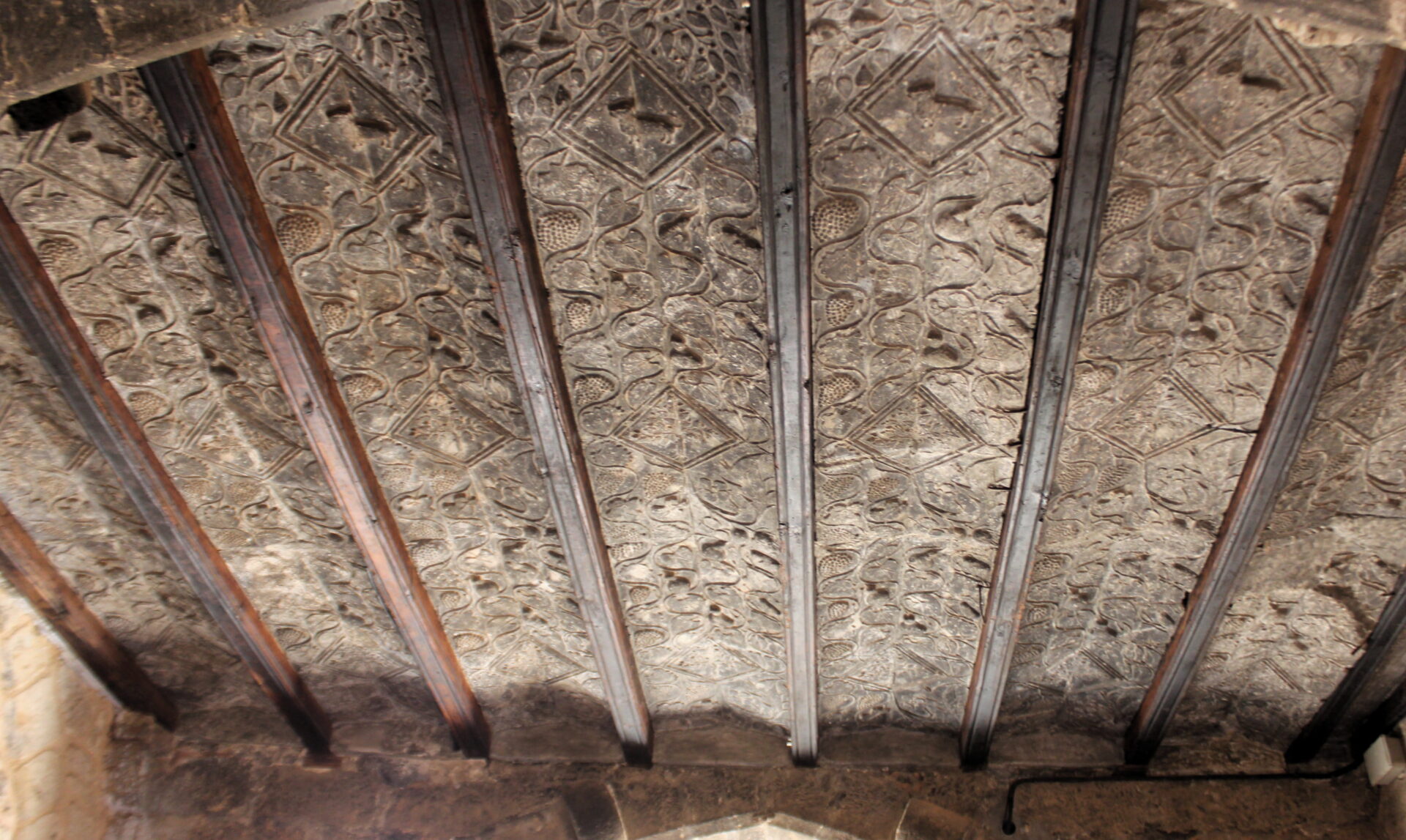 Alfare de madera y yeso con hoas y uvas en los pueblos del Matarraña