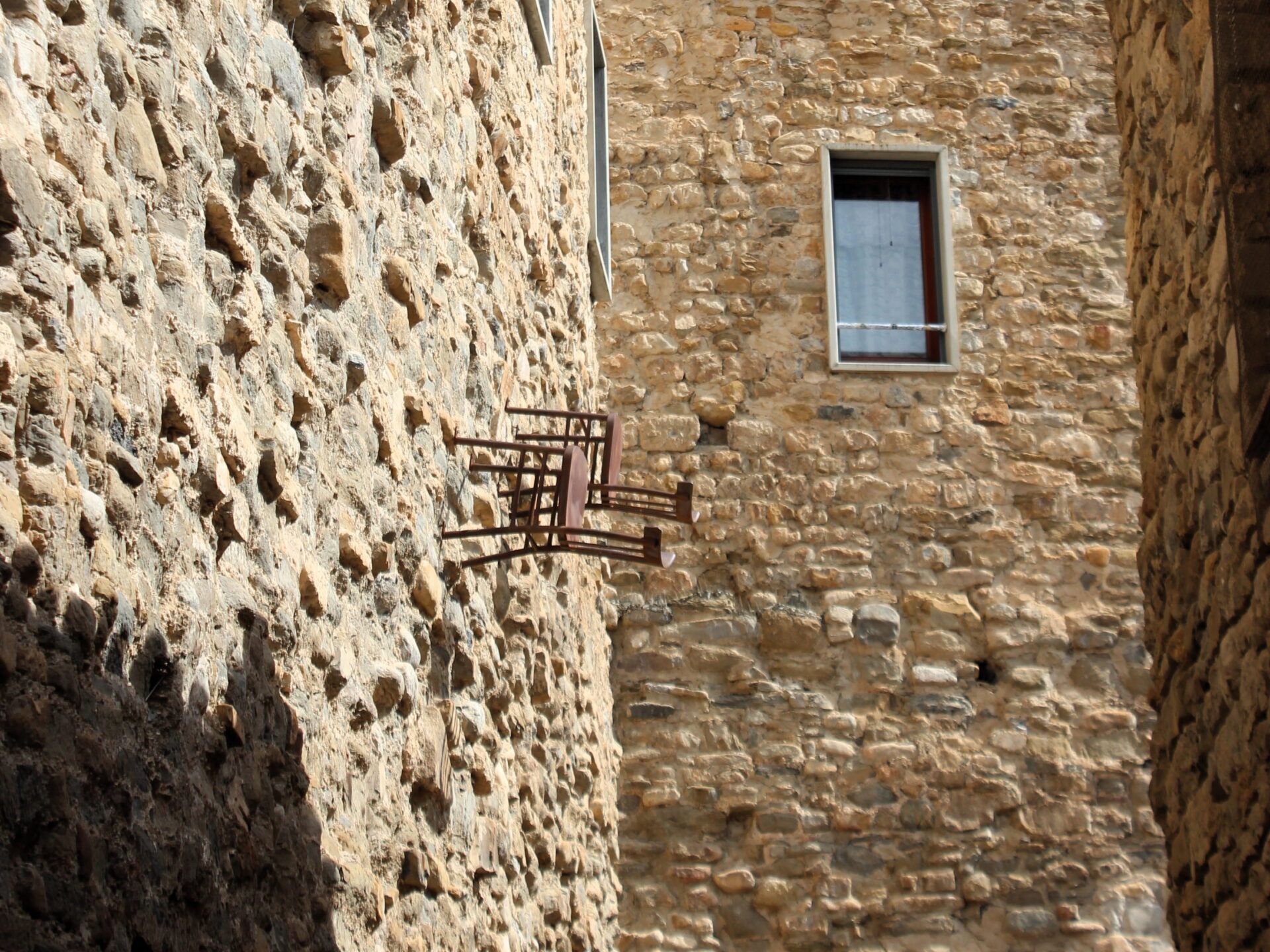 Sillas de las brujas en las fachadas de las paredes por las calles de la villa medieval 