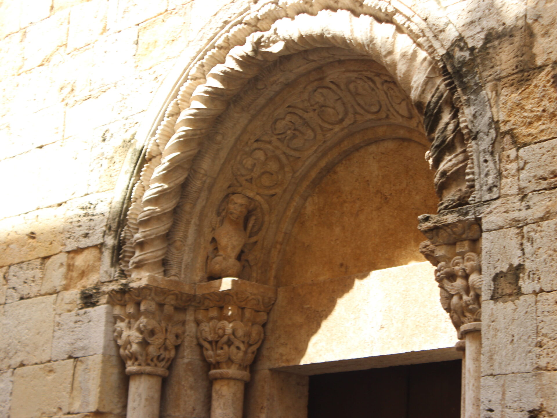 Portada románica con arquivoltas, capiteles y relieves en la iglesia de San Vicenç. Villa medieval