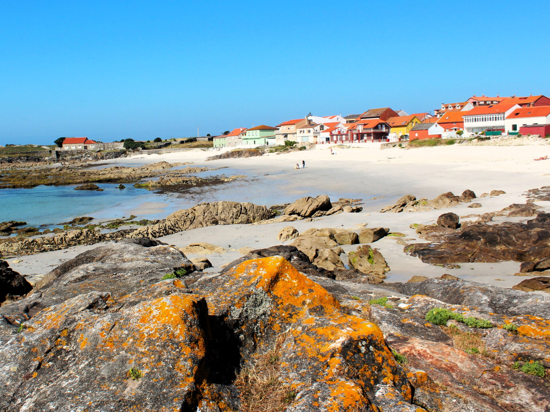 Cala con casas de colores en Corrubedo
